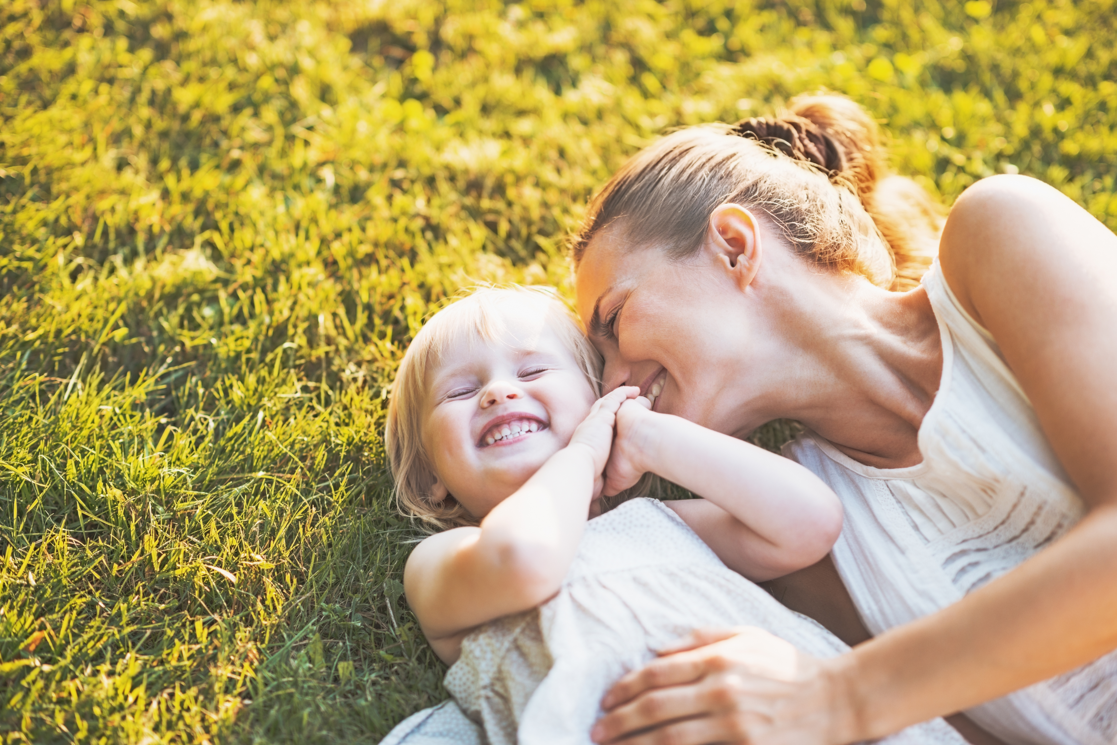 Happy mother and baby laying on meadow photo mom baby in field
