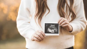 Patient holding an ultrasound image after a successful frozen embryo transfer (FET)