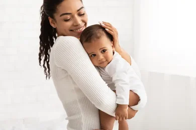 Smiling mother holding her baby after her IUI treatment journey with Positive Steps Fertility