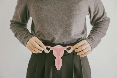 Woman holding a uterus model to represent PCOS and hormonal causes of female infertility during a fertility evaluation at Positive Steps Fertility