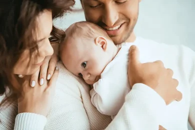 Happy couple with their newborn after fertility journey with Preimplantation Genetic Testing (PGT) at Positive Steps Fertility