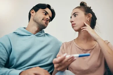 Couple looking at a pregnancy test while navigating infertility and exploring fertility testing and treatment at Positive Steps Fertility in Mississippi and Louisiana